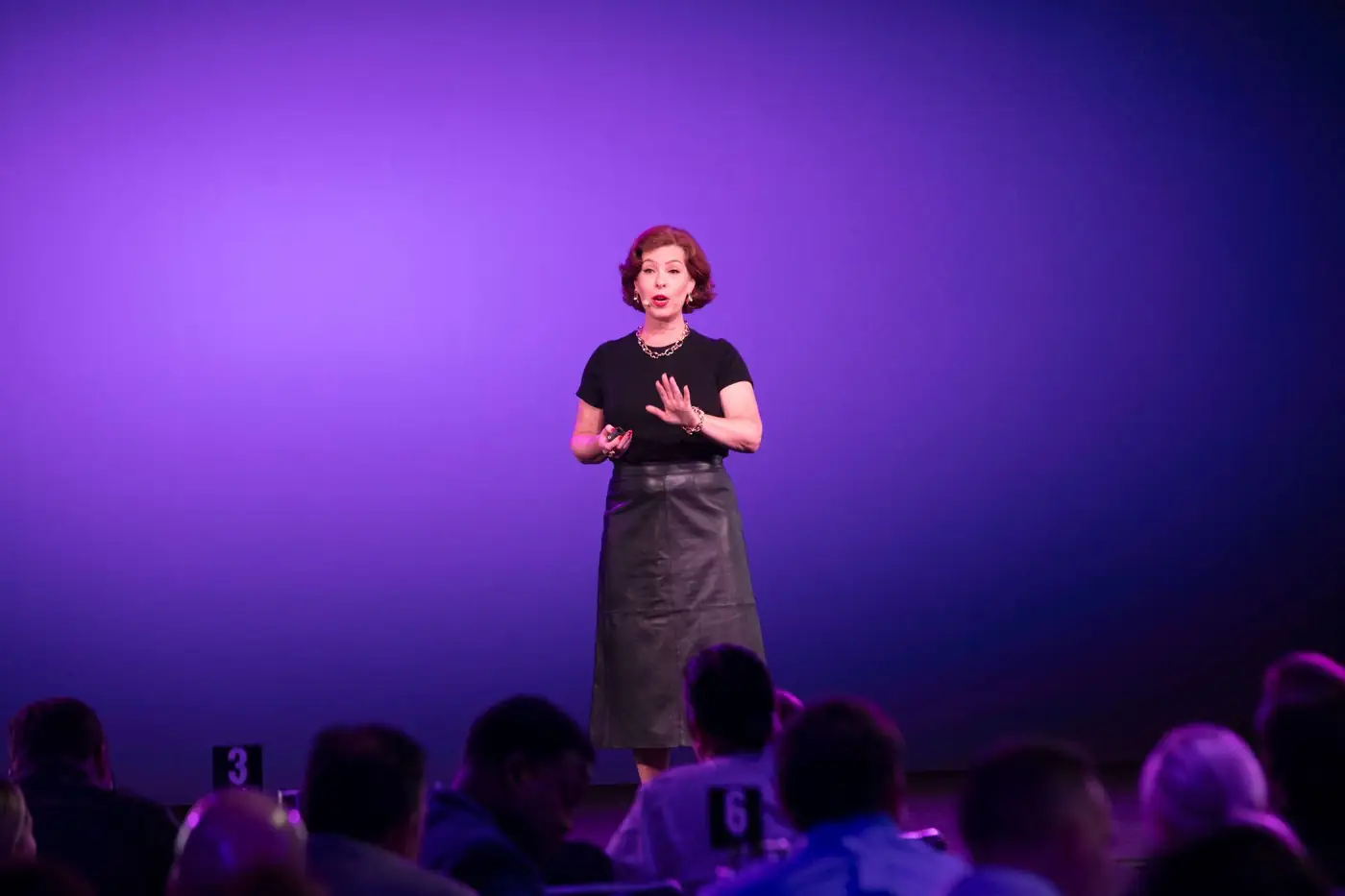 A keynote speaker addressing a packed room at a corporate event